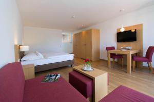 a hotel room with a bed and a table and chairs at Hotel Seepark Garni in Überlingen