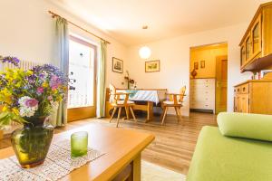 a living room with a vase of flowers on a table at Apartements Mitterstill in Völs am Schlern