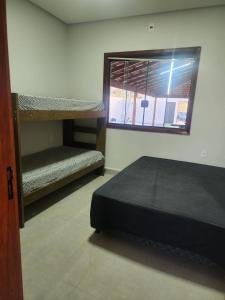 a room with two bunk beds and a window at Sítio Das Andorinhas in Capitólio