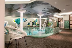 a water slide in a hotel lobby with two chairs at Gewandhaus Dresden, Autograph Collection in Dresden