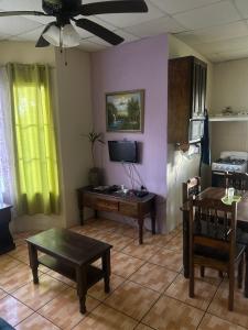 Una sala de estar con un sofá, una mesa y un televisor. en Linda Vista Cabins, en Boquete