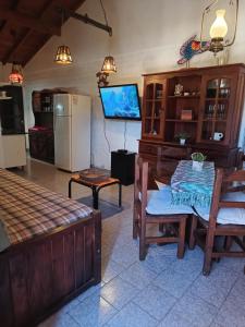 a living room with a table and a television at Alquilo casa dúplex!!! in Necochea +8 photos