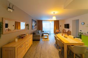 a kitchen and living room with a table and a couch at Fabulous Views Silver Mountain 3 Rooms Apartment in Poiana Brasov
