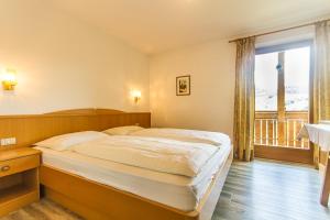 a bedroom with a large bed and a balcony at Apartements Mitterstill in Völs am Schlern