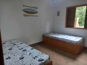 a bedroom with two beds and a window at Casinha mar e mato in Ubatuba