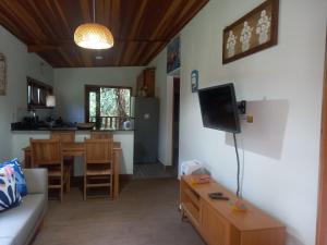 a living room with a couch and a table at Casinha mar e mato in Ubatuba