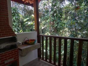 a balcony with a view of a forest at Casinha mar e mato in Ubatuba