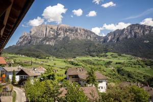a view of a mountain from a town with houses at Apartements Mitterstill in Völs am Schlern