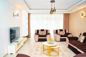 a living room with two couches and a tv at Sunninghills in Nairobi