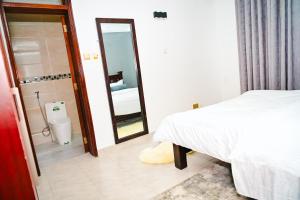 a bedroom with a bed and a bathroom with a mirror at Sunninghills in Nairobi +19 photos