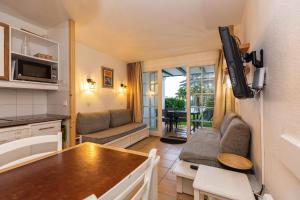 a small kitchen and living room in a caravan at Domaine Bordaberry T2 Jardin et Superbe piscine in Urrugne