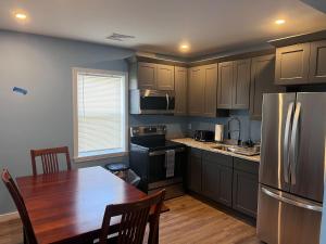 a kitchen with a wooden table and a refrigerator at Almira Properties Apartments in Providence