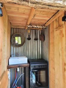 une cuisine avec un évier et une cuisinière dans l'établissement Gîte de France La yourte joulebois - Gîte de France 2 personnes MAE-6961, à Saillac