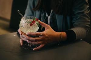a woman holding a drink with a strawberry on it at Boutique Hotel Pachers in Bressanone