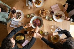 a group of people sitting around a table eating food at Boutique Hotel Pachers in Bressanone
