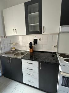 a kitchen with white cabinets and a sink at Apartment Crystal in Belgrade