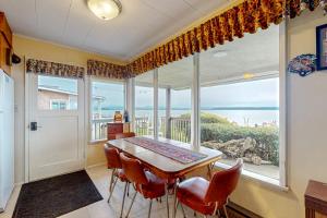 a dining room with a table and chairs and a large window at Blue Heron in Lona Beach