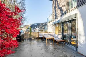 a patio with a couch and a wooden table at LIBORIA I Stylisches Haus I Sauna I Wellness in Starnberg