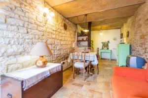 Habitación con pared de piedra y mesa con lámpara. en Appartamento nel Castello presso Gubbio, en Fossato di Vico
