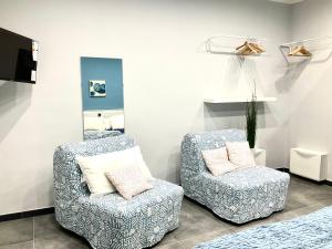 una camera con due sedie, una TV e un letto di Siculahome23 a Catania