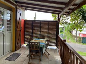 a patio with a table and chairs on a balcony at Chez sidoine Meublé 1 chambre in Le Moule