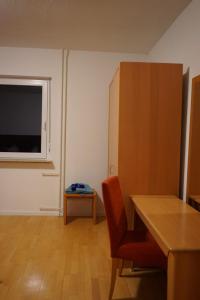 a room with a table and a chair and a window at Bimbacher Betten in Bimbach
