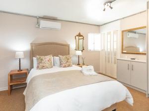 a bedroom with a large white bed and a mirror at Mountain View Guesthouse in Springbok +9 photos