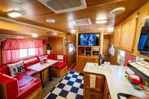uma cozinha com cadeiras vermelhas e uma pia em um trailer em Darling Daisy Retro RV Adventure em El Cajon