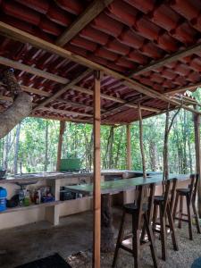 a table in a pavilion with chairs in the woods at Menhir Maya in Xetna +19 photos