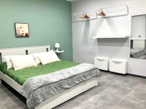 una camera con un letto verde e bianco di Siculahome23 a Catania