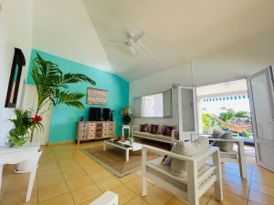 a living room with blue walls and a ceiling at Villa Amaryllis in Le Gosier