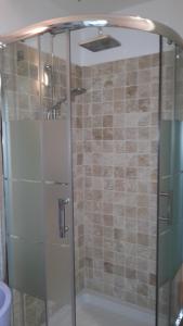 a shower with a glass door in a bathroom at Le Saint Léonard...Il est bleu in Honfleur