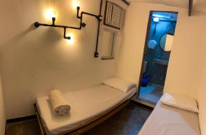 a small room with a small bed and a mirror at Bella Ciao Hostel in Rio de Janeiro +92 photos