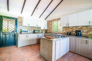 a kitchen with white cabinets and a stove top oven at Casa Matiz - Vistas increíbles cerca de Anapoima in Apulo