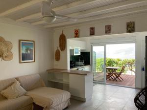 a living room with a couch and a kitchen at Ans'O - Les Anses d'Arlet in Les Anses-dʼArlets