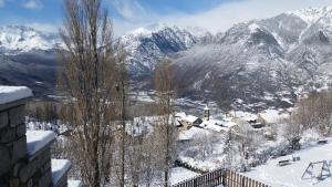 vistas a una montaña nevada con una ciudad en Apartamentos HG Cerler, en Cerler