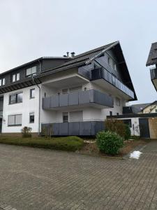 Un edificio blanco con balcones a los lados. en Winterberg Appartement 21068, en Winterberg