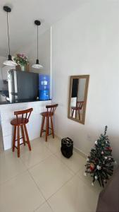 a kitchen with a christmas tree and two chairs at Aluga-se casa em arembepe in Camaçari