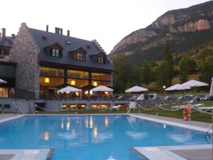 a hotel with a swimming pool in front of a building at Apartamentos HG Cerler in Cerler