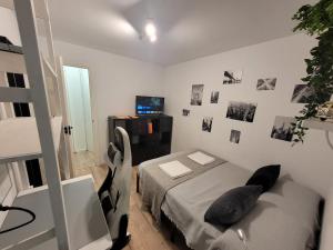 ein Schlafzimmer mit einem Bett in einem Zimmer mit Fotos an der Wand in der Unterkunft Habitaciones con vistas Madrid in Madrid