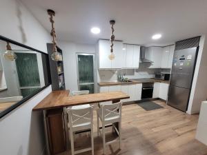 eine Küche mit einem Holztisch und weißen Schränken in der Unterkunft Habitaciones con vistas Madrid in Madrid