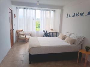 a bedroom with a bed and a chair and a window at Apartamento Campestre in Fusagasuga +25 photos