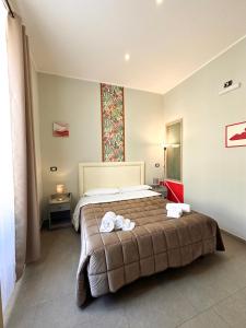 una camera da letto con un letto con due asciugamani sopra di Welcome to I Colori di Napoli a Napoli