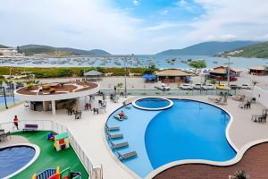an overhead view of a pool at a resort at Arraial | Apartamento com 3 suítes e Vista Mar in Arraial do Cabo