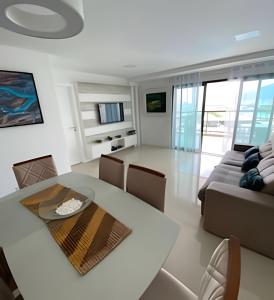 a living room with a table and a couch at Arraial | Apartamento com 3 suítes e Vista Mar in Arraial do Cabo