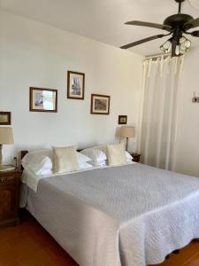 a bedroom with a white bed with a ceiling fan at Villa Pietrafiore in Monterosso al Mare