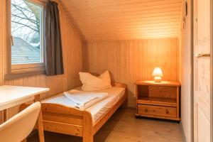 a small room with a bed and a window at Wildgans 65 in Mirow
