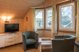 a living room with two chairs and a television at Wildgans 65 in Mirow