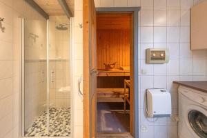 a bathroom with a shower and a washing machine at Wildgans 65 in Mirow +13 photos