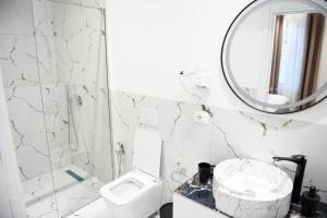 a bathroom with a toilet and a mirror at Alpha Rooms in Berat